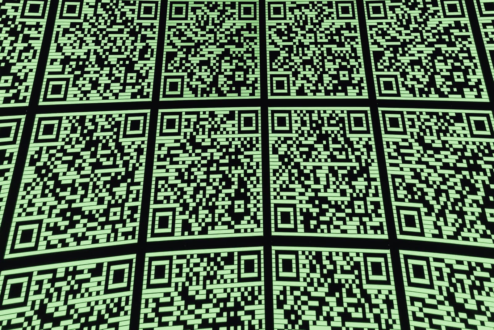 A wall of printed QR codes in a grid